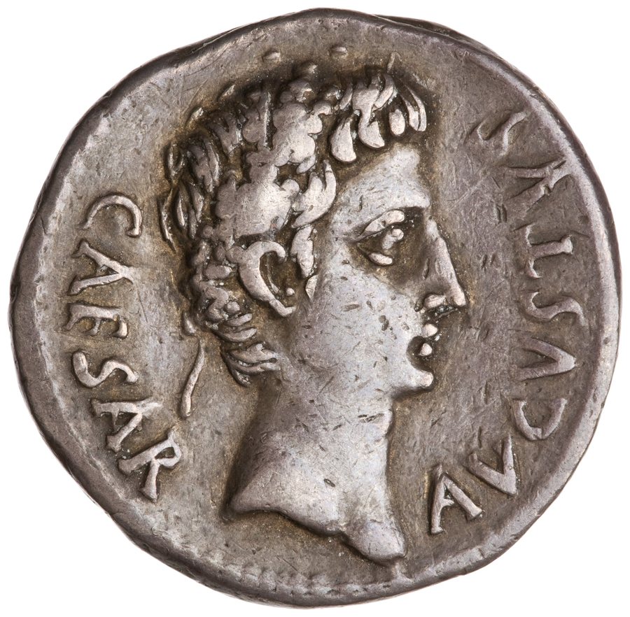 A bright silver Roman coin showing the head of Augustus in profile, with clear lettering.
