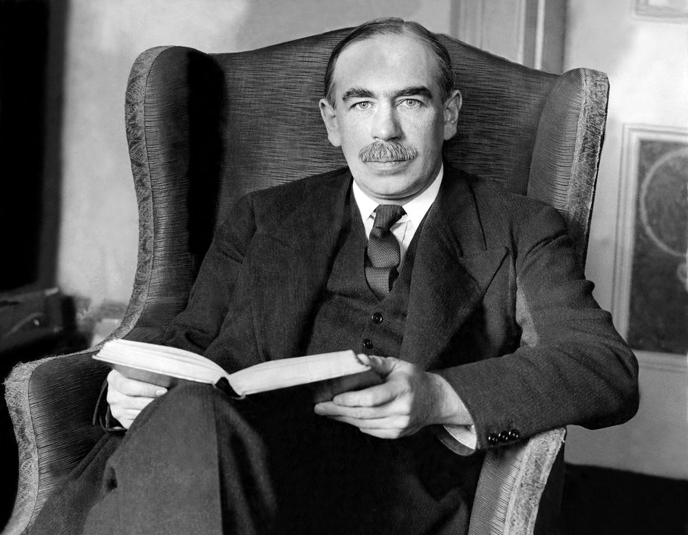 John Maynard Keynes seated, holding a book, photographed in 1929.
