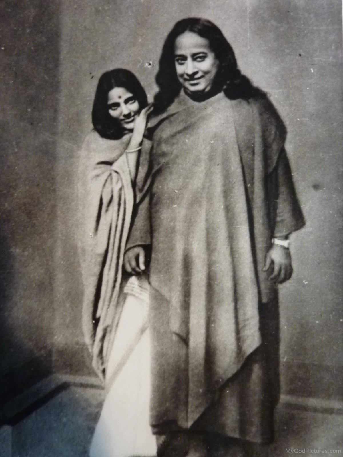 A black-and-white photograph of Paramahansa Yogananda standing beside Anandamayi Ma in 1935.