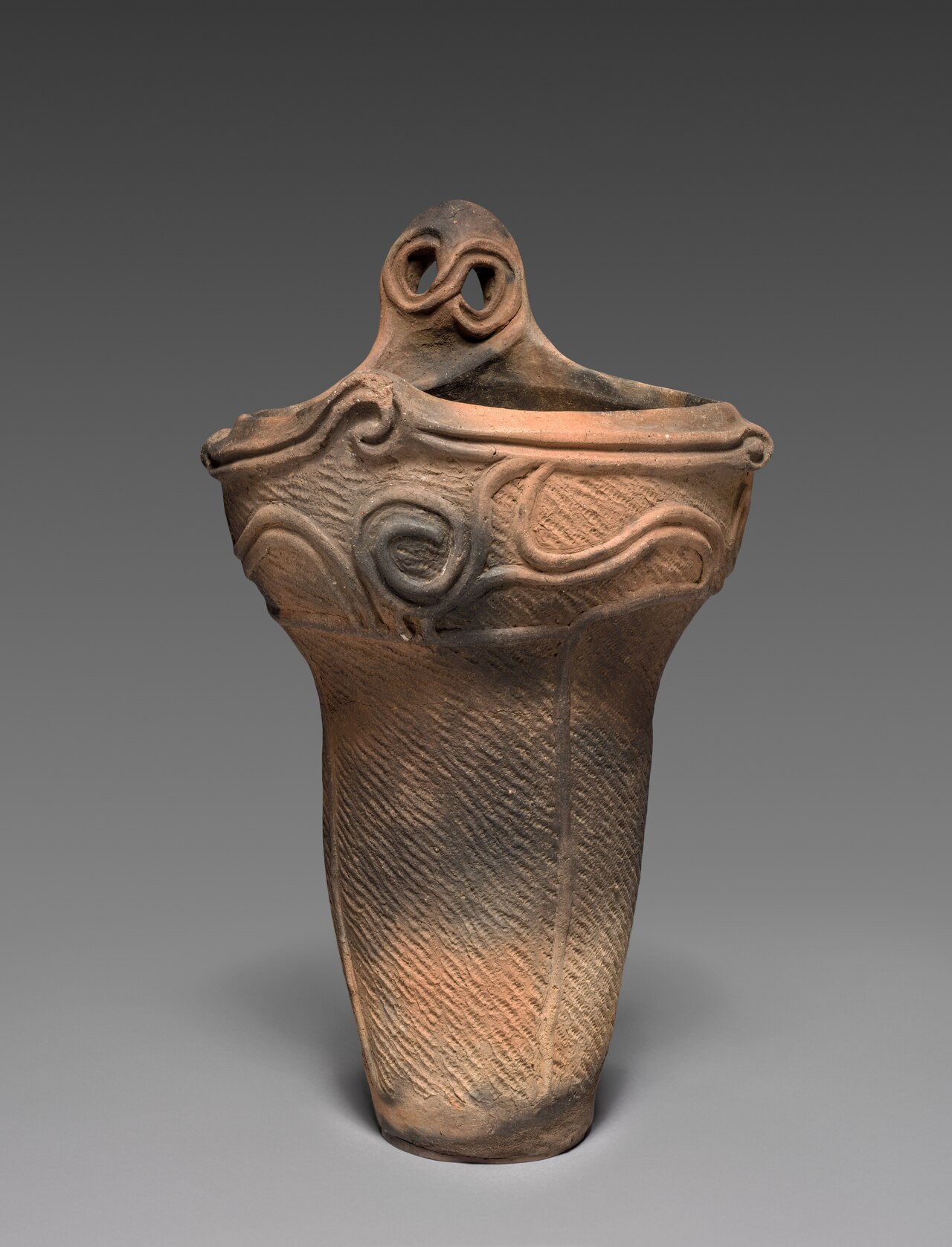 A Middle Jomon period cooking vessel with elaborate sculpted rim decoration.