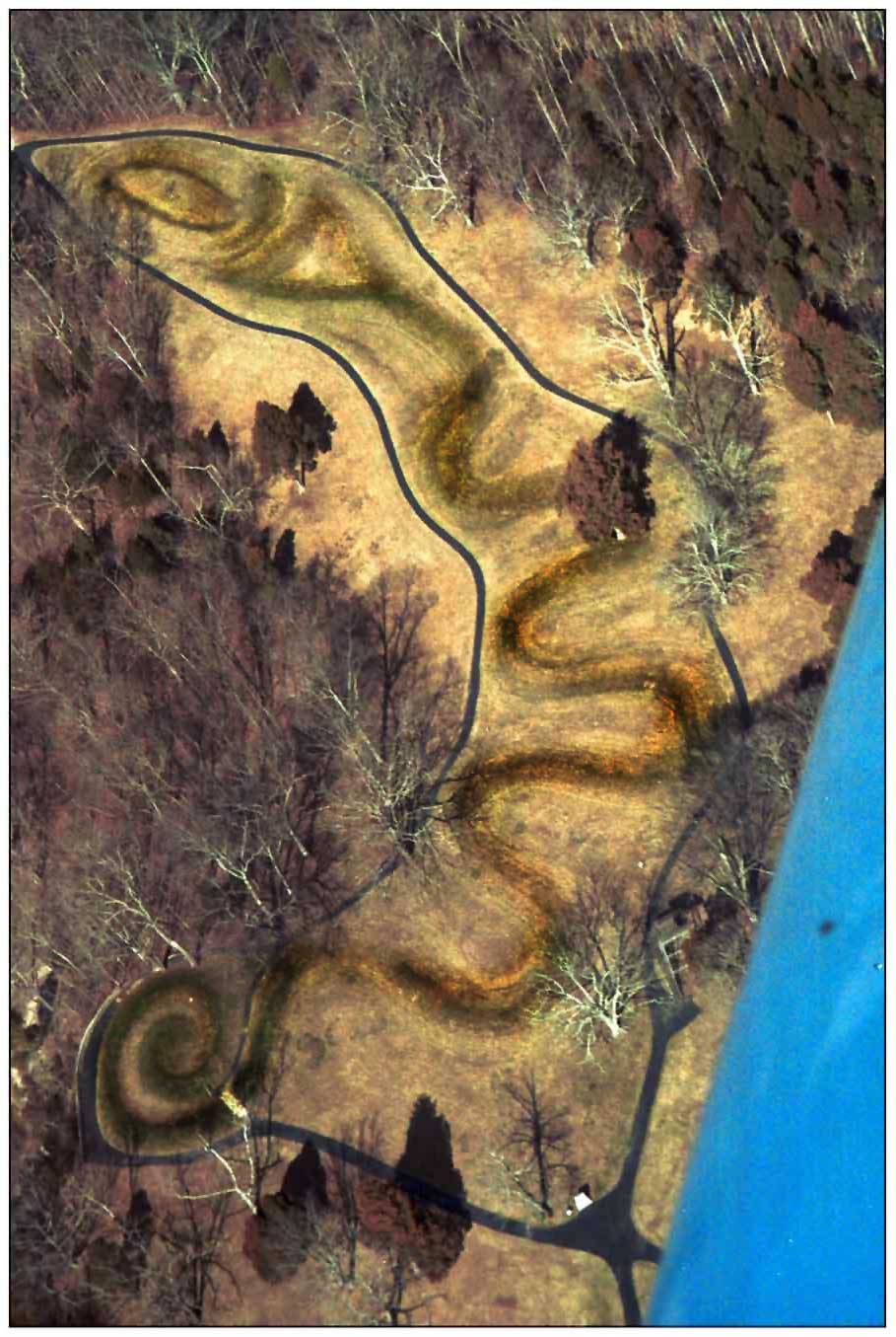 Aerial photograph of the Great Serpent Mound in Ohio, a long undulating earthen serpent with a coiled tail.