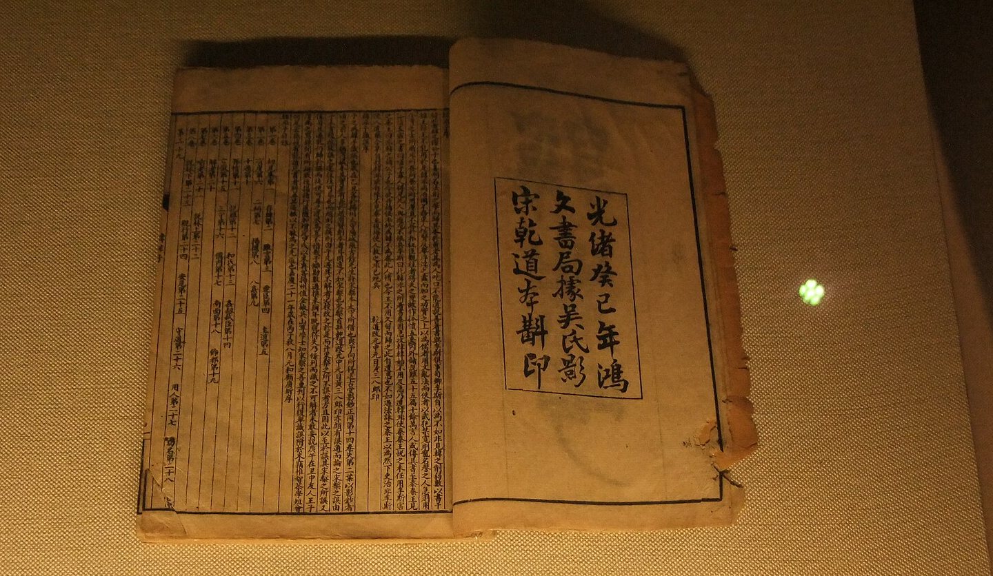 An old printed copy of the Hanfeizi, open at its title page, in a museum case